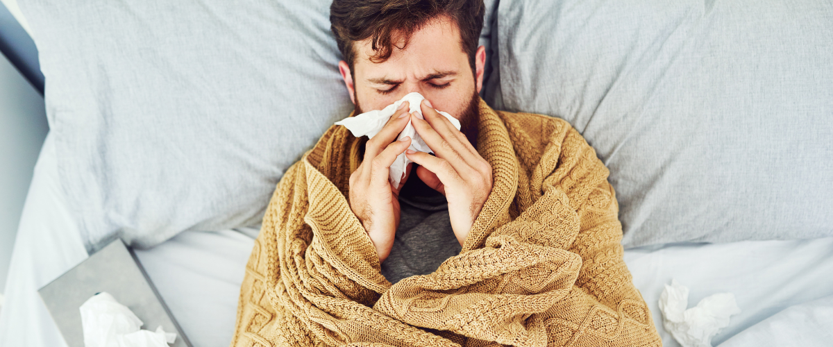 Man ligt met een verkoudheid in bed